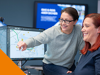 Zwei Frauen schauen auf einen Bildschirm